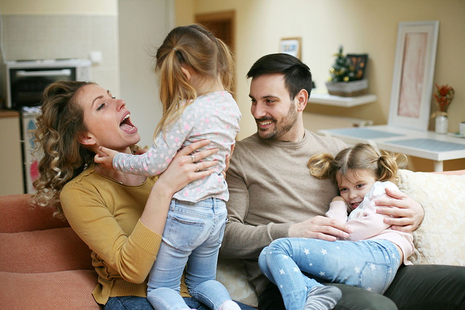 Happy family playing on the couch